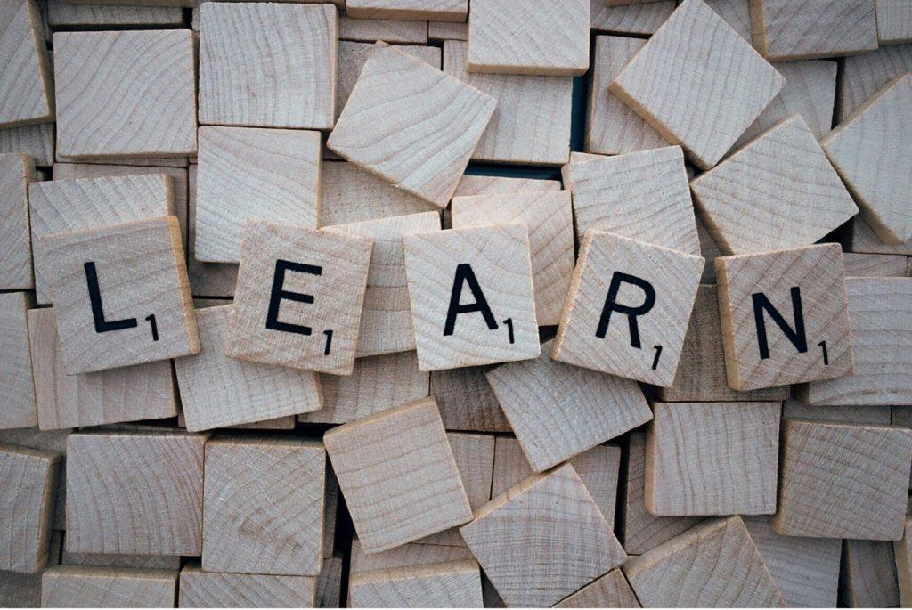New Year's Resolutions from Tampa Counseling Place in Tampa, Florida: Wooden Scrabble tiles spelling out 'LEARN' arranged on a background of scattered blank wooden tiles